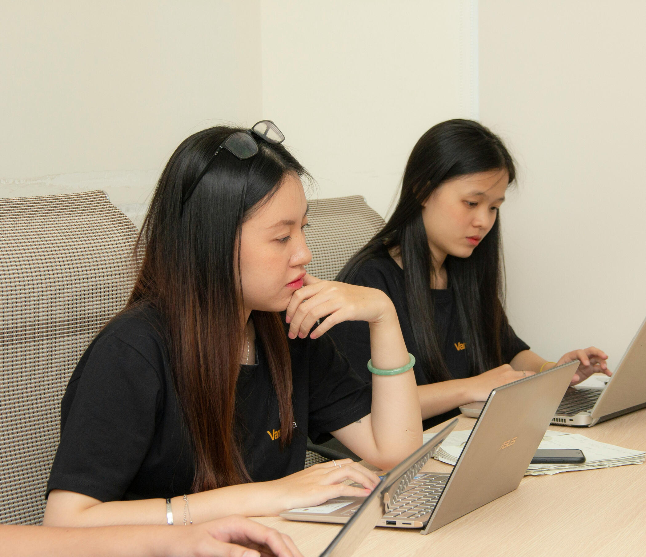 Photo by Van Tay Media on Unsplash Two women with straight hair in a well-lit office working on their computers.