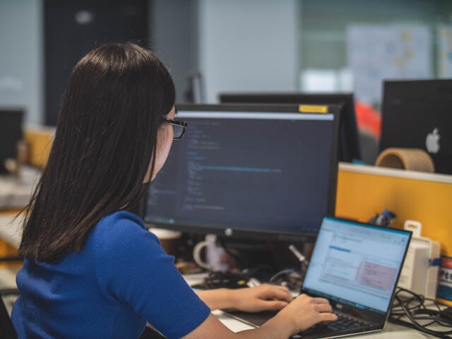 Photo by Van Tay Media on Unsplash Two women with straight hair in a well-lit office working on their computers.
